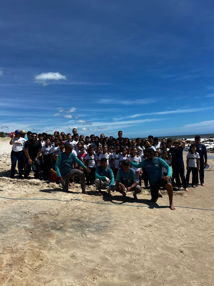 Grupo de alunos e equipe na praia